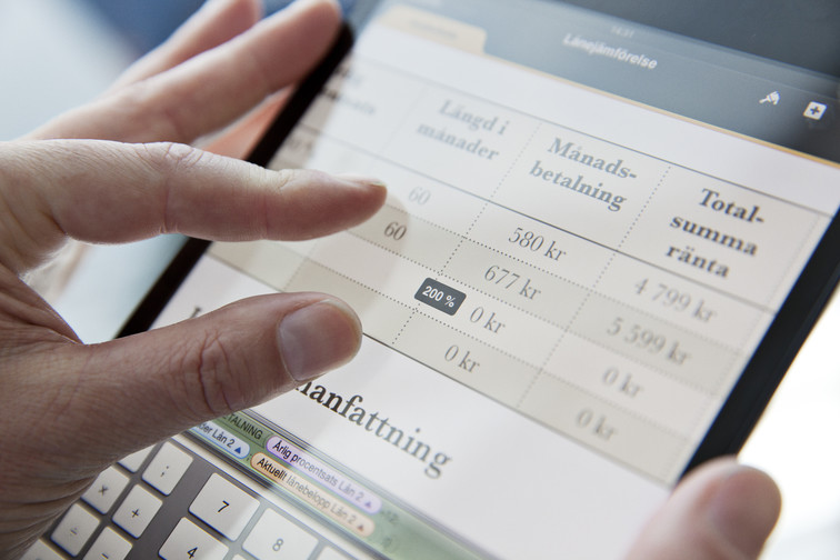 A person's hand zooming in on a financial application on an iPad.