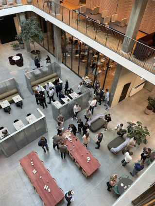 A bird's eye view of people standing in the cafeteria at Visma's Copenhagen office.