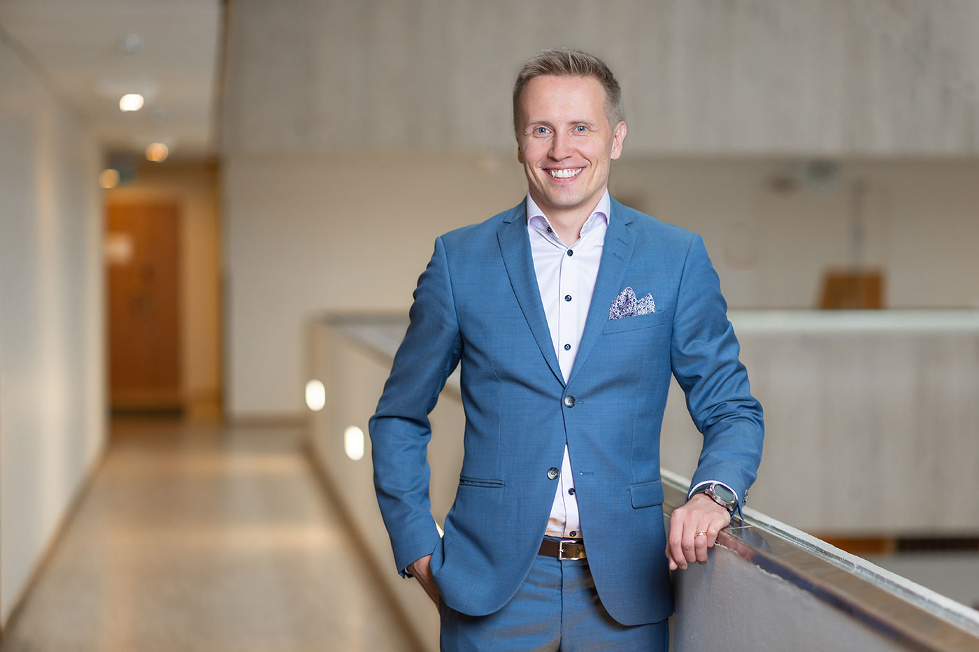 Ari-Pekka Salovaara, Visma's SMB Segment Director, stands in a hallway and smiles at the camera.