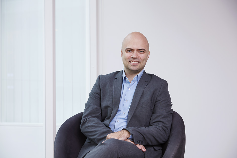 Christian Westlye Larsen, Visma CTO, sits in a chair and smiles at the camera.