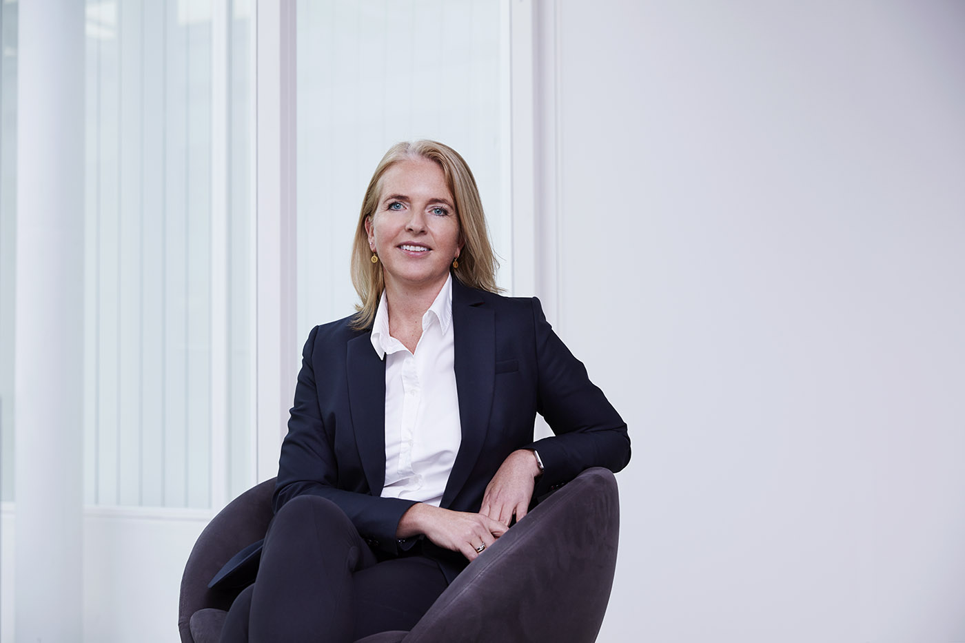 Ellen Furru, Visma COO, sits in a chair and smiles at the camera.